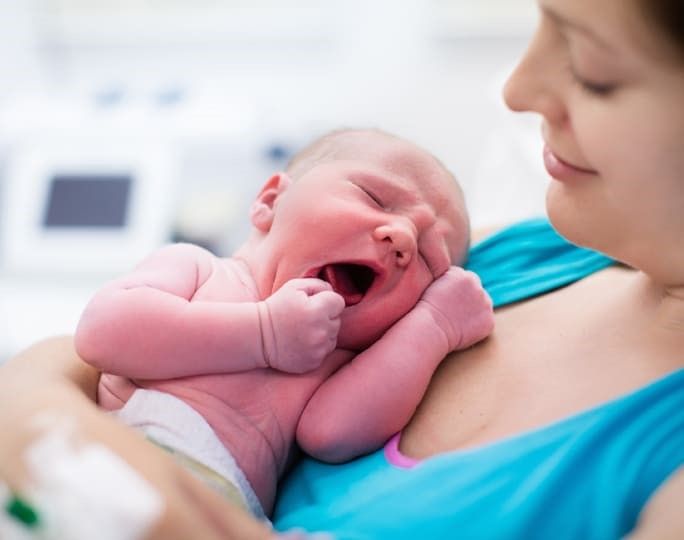 Ein neugeborenes Kind in den Armen der Mutter